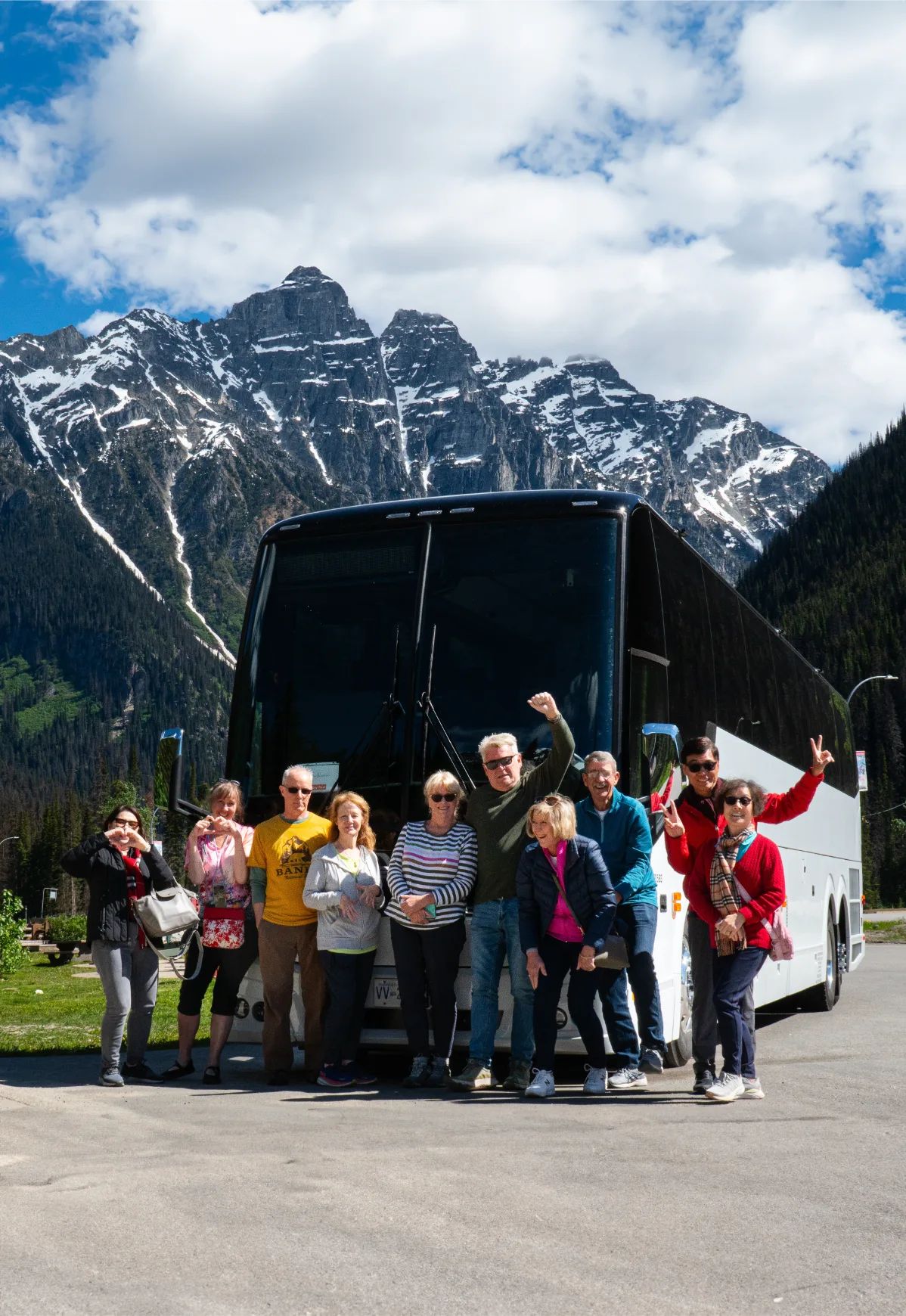 A group posing in front of the Key West Travel Bus in the Canadian Rockies
